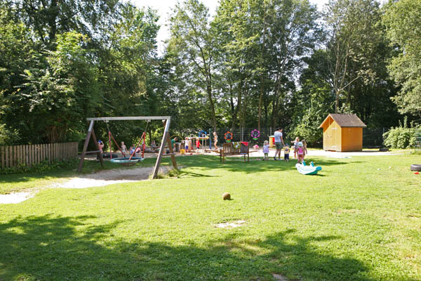 In unserem Garten gibt es viel Platz zum Spielen und Toben, einen groen Sandkasten mit Matschanlage, eine Nestschaukel, eine Spielwohnung in unserem Bauwagen, einen Rutschhgel mit Tunnel, ...